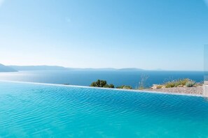 A clear view of a swimming pool with a distant body of water and a clear sky. - Villa Aristea with sea view, jacuzzi&infinity pool (Ripenda Kosi)