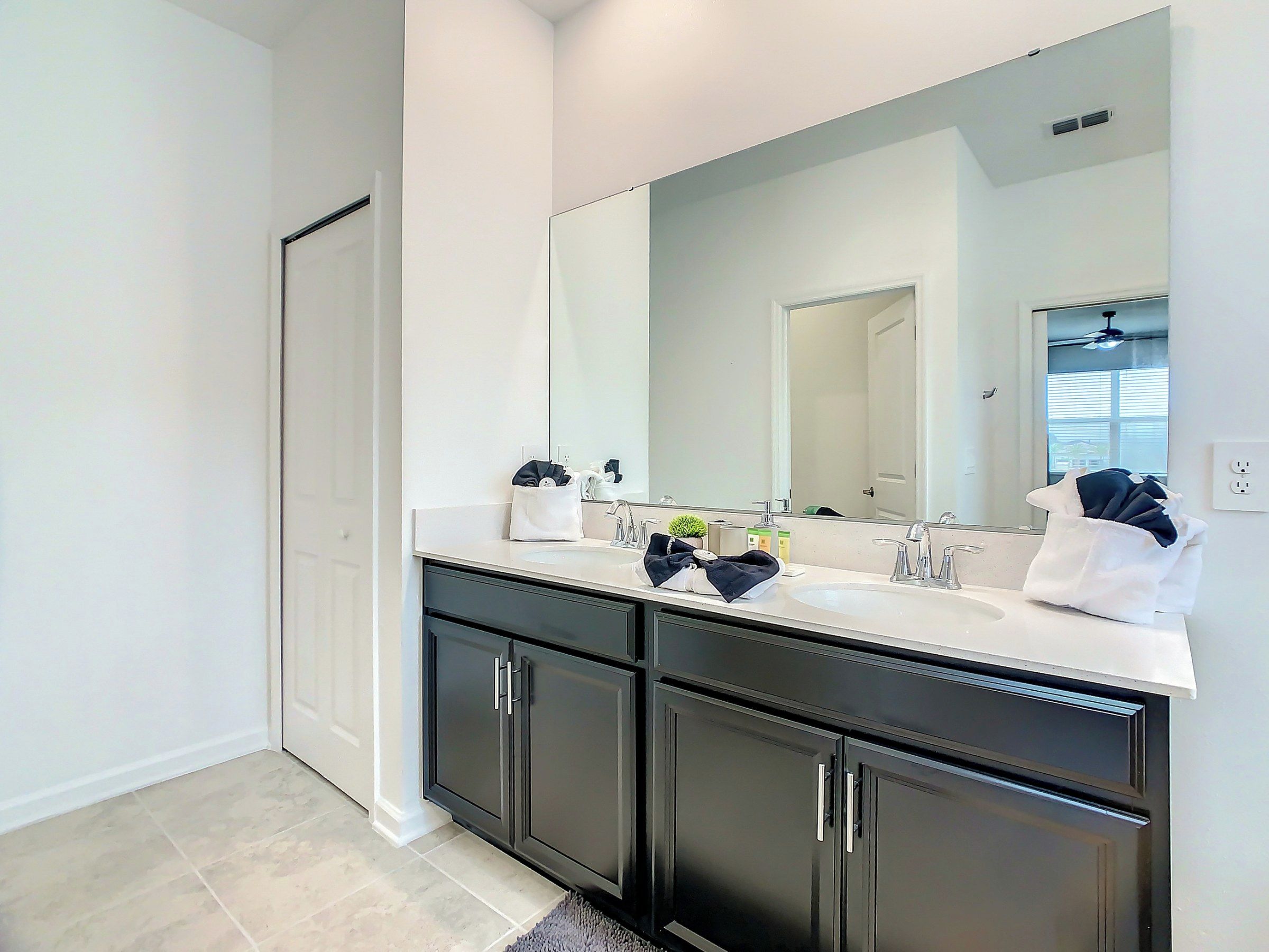 A modern bathroom with a double vanity, a large mirror, and a walk-in shower.