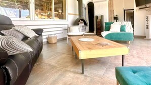 A living room with a sofa, a wooden coffee table, and a teal armchair. - Villa Anchorage, SEA VIEW, HEATED POOL , no vis-a-vis (PORTO VECCHIO)
