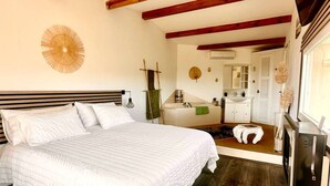 A bedroom with a bed, a wooden headboard, a wall-mounted lamp, a ladder, a mirror, a sink, and a refrigerator. - Villa Anchorage, SEA VIEW, HEATED POOL , no vis-a-vis (PORTO VECCHIO)