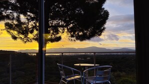 A balcony with two metal chairs and a small round table, overlooking a scenic landscape with mountains and a sunset. - Villa Anchorage, SEA VIEW, HEATED POOL , no vis-a-vis (PORTO VECCHIO)