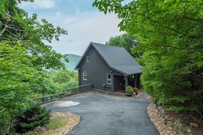 Exterior view of Misty Mountain Hideaway & paved parking area alongside the house.