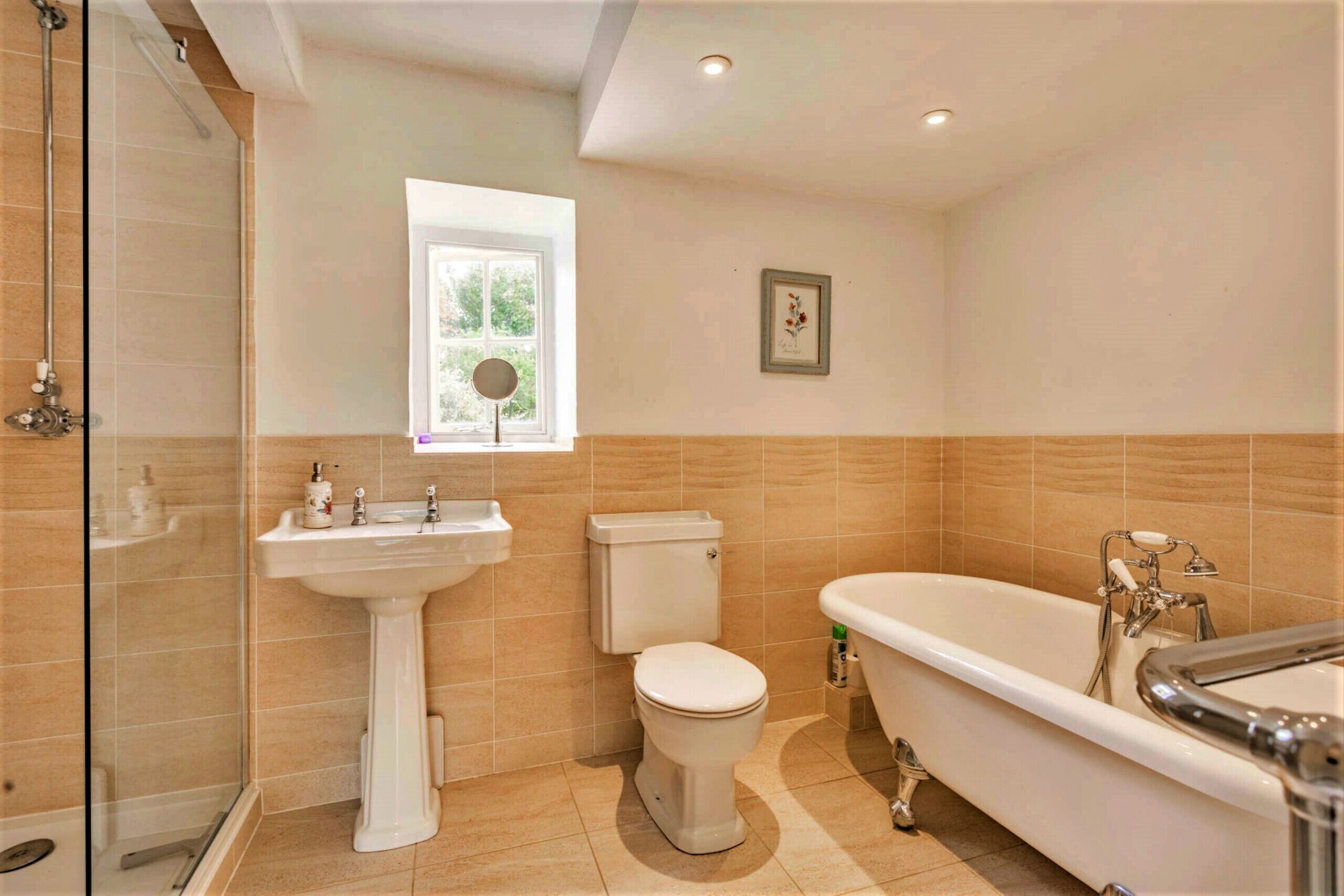 A bathroom with a shower, toilet, sink, and bathtub.