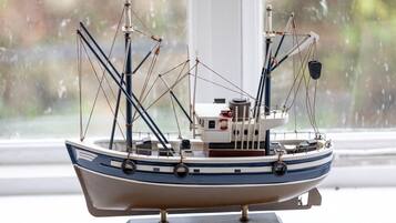 Een model schip op een voetstuk, met een label 'TRAWLER' op de onderkant.