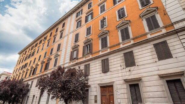 A multi-story building with a classic architectural style, featuring symmetrical windows and a central entrance. - femasuites (Rome)
