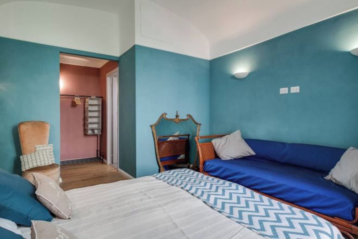 Un dormitorio con una cama, una silla y un armario.