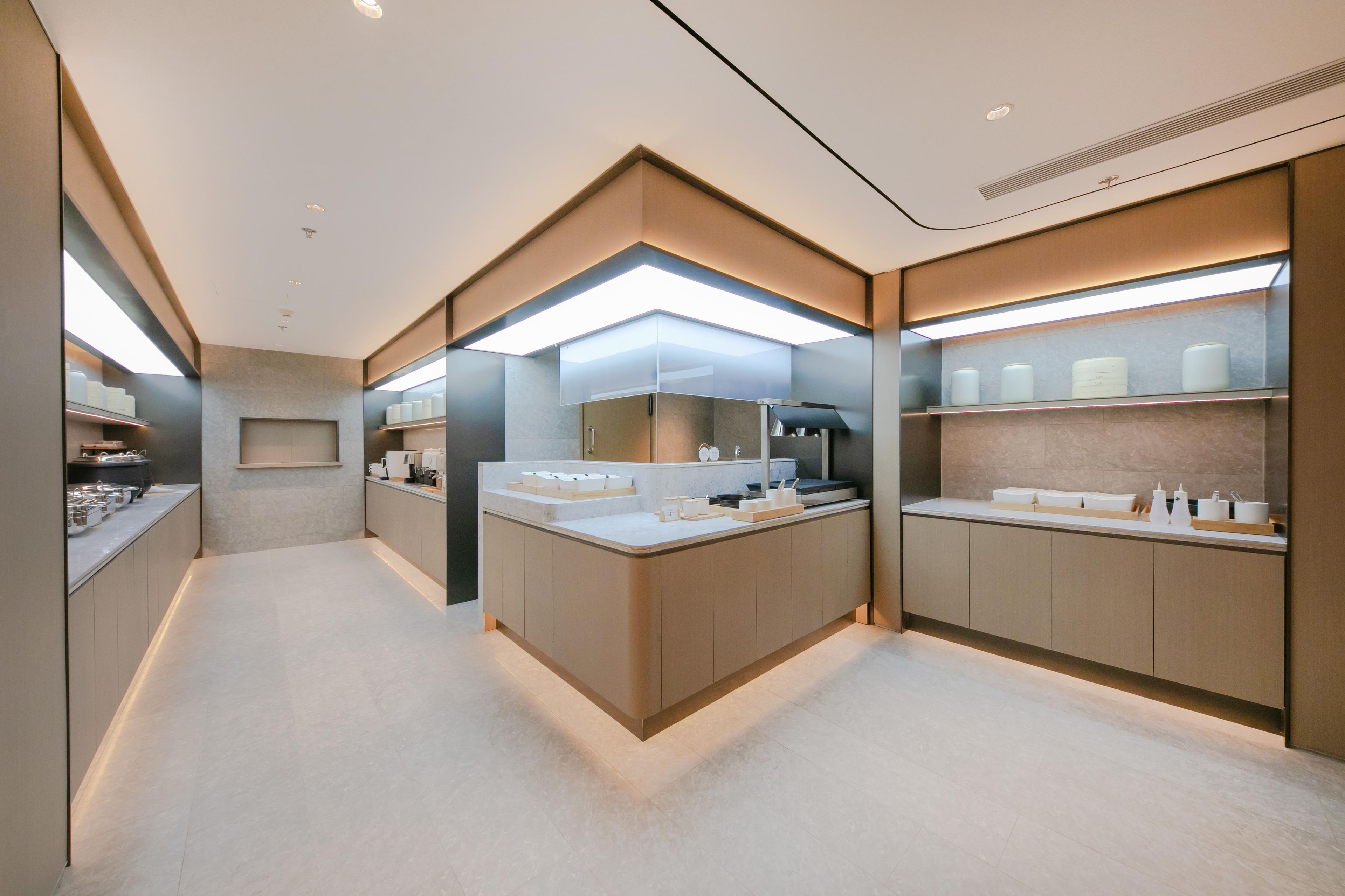 Una cocina moderna con una isla central, electrodomésticos integrados y mucho espacio de almacenamiento.