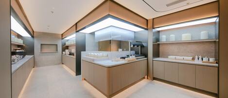 Un baño moderno con una isla central, estantes integrados y un espejo grande.