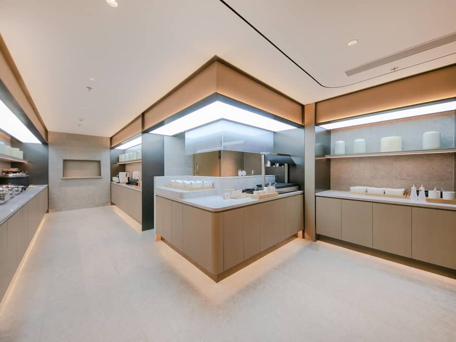 A modern bathroom with a central island, built-in shelves, and a large mirror.