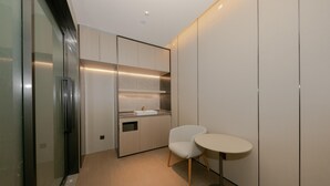 Une cuisine moderne dotée d’un évier encastré, d’une petite table à manger et d’une chaise.