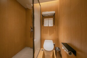 Ein modernes Badezimmer mit Duschkabine aus Glas, Toilette und Handtuchhalter.