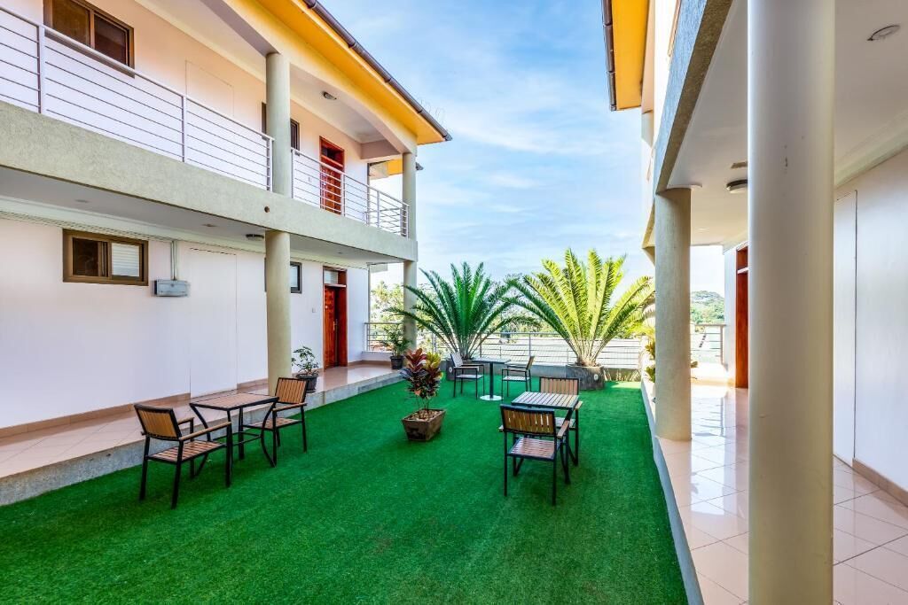 A courtyard with artificial grass, outdoor seating, and potted plants.