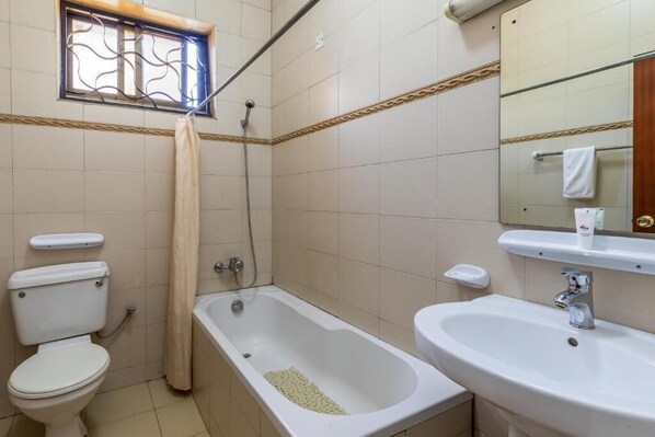 A bathroom with a toilet, bathtub, and sink.