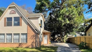 A two-story house with a brick facade, a small attached garage, and a paved driveway leading to the front door. - Beautiful suite with separate entrance. (New Port Richey)