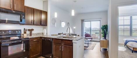 Enjoy meals in this well-lit kitchen with a central island and sink, connected to a dining area with outdoor views.