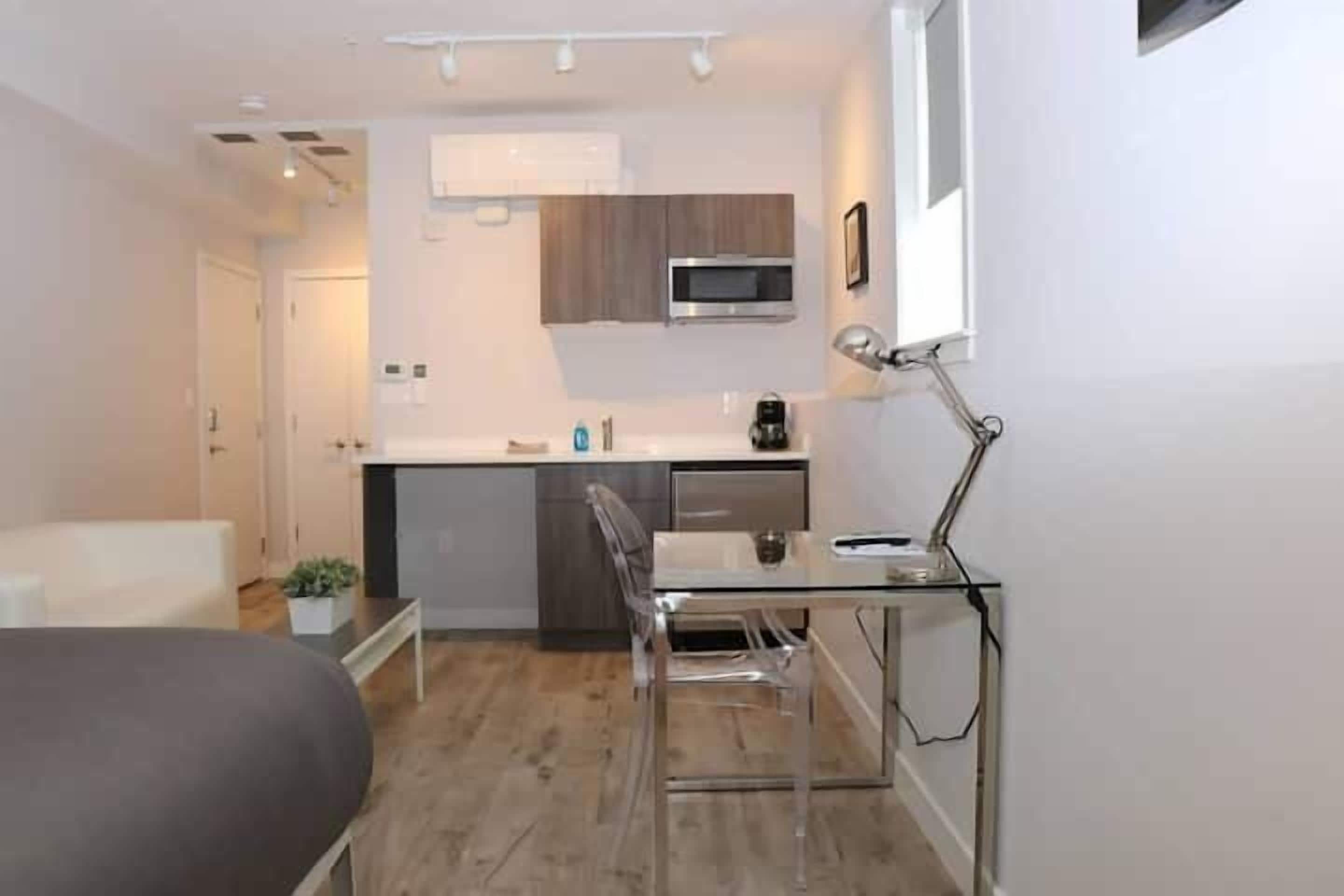 A compact living space with a kitchenette, a dining area, and a bed.