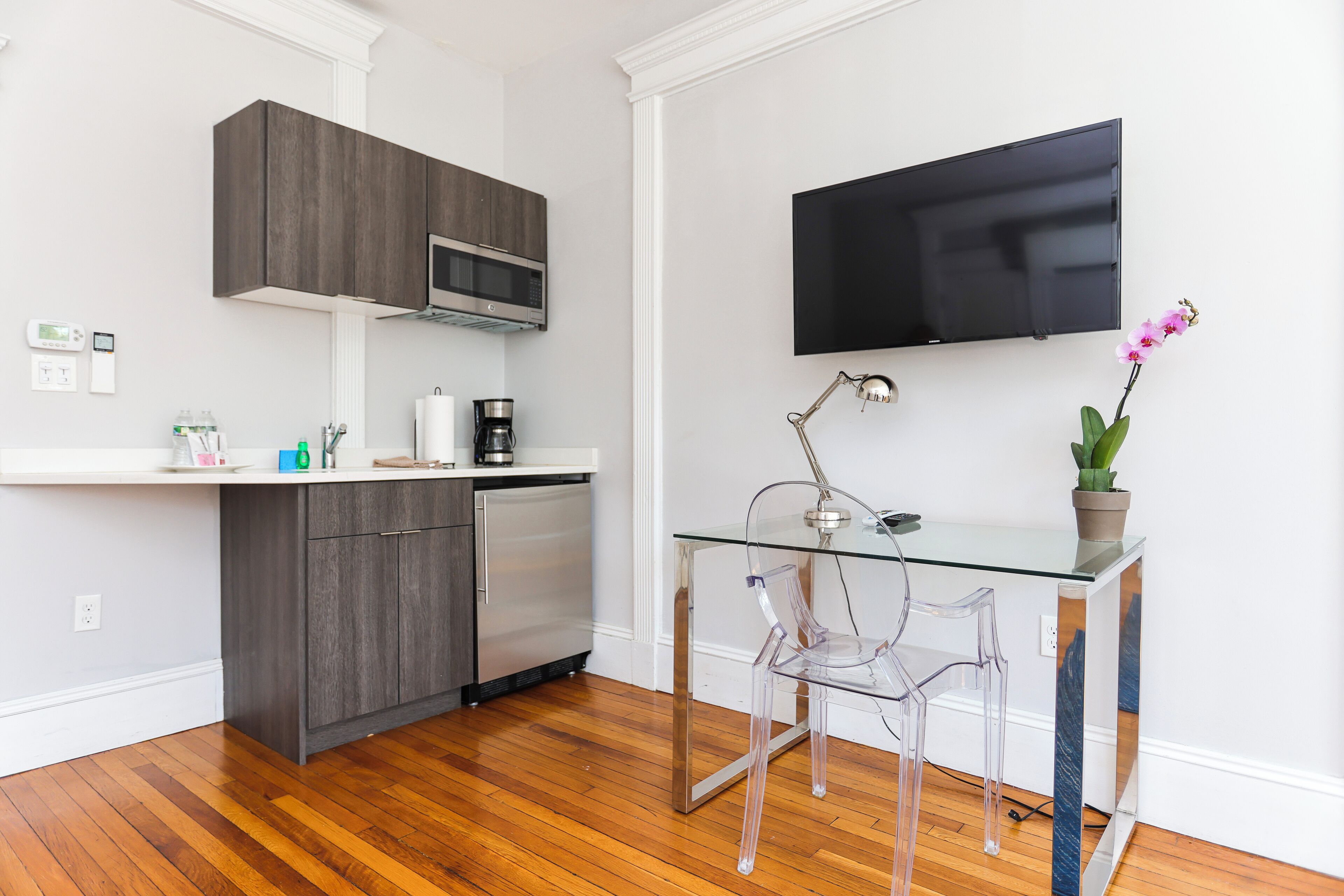 A modern kitchen with dark cabinets, a microwave, and a coffee maker on the counter.