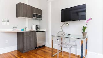 A modern kitchen with dark cabinets, a microwave, and a coffee maker on the counter.