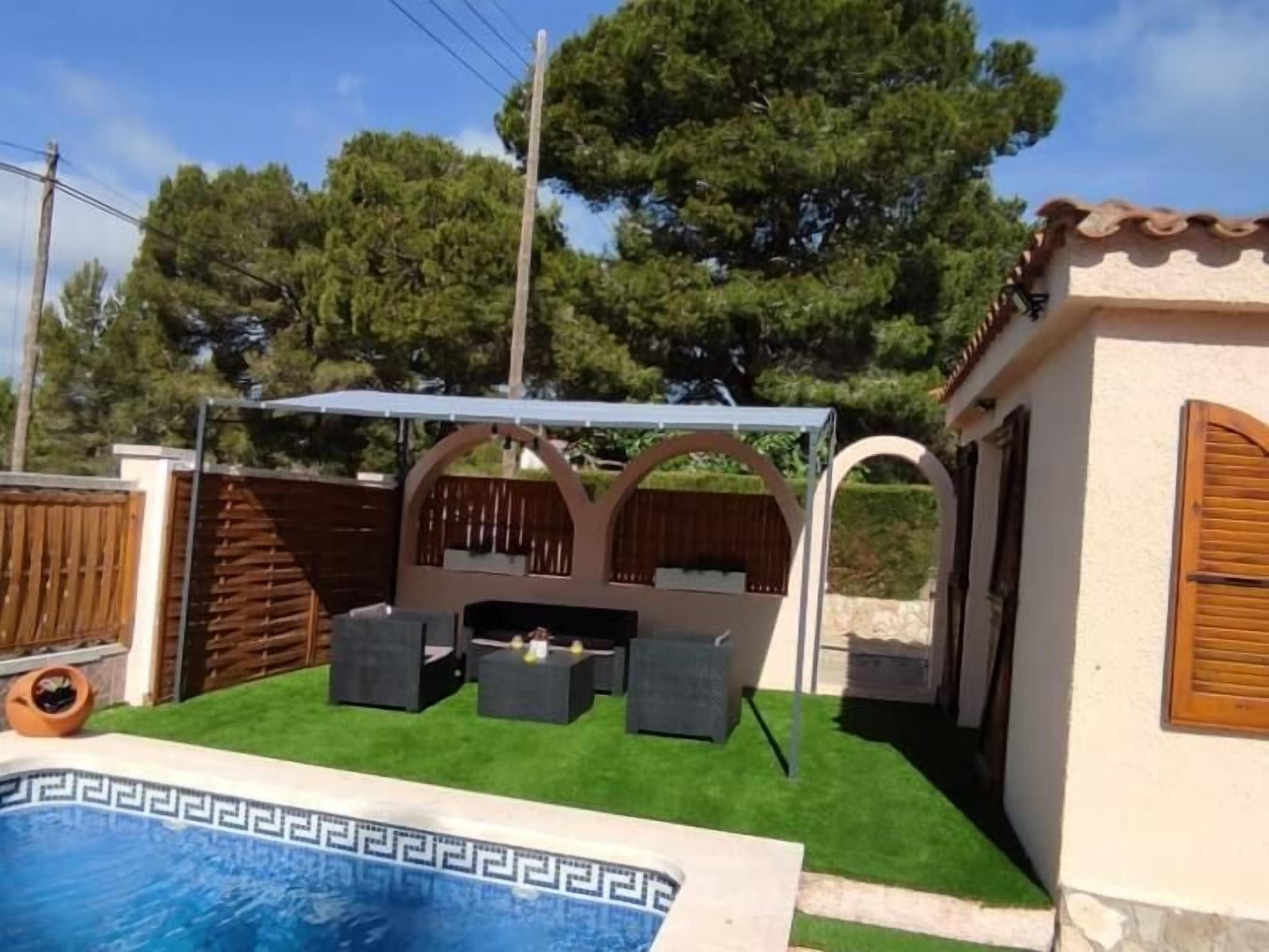 Ein Garten mit Pool, Sitzgelegenheiten im Freien und einer Pergola.