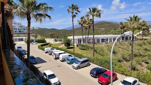 A parking lot with several cars, palm trees, and a building with a modern design in the background. - Attic, large terrace. 2 Km. from Fuengirola. Wyndham Resorts Mijas-Costa area. (Mijas-Costa)