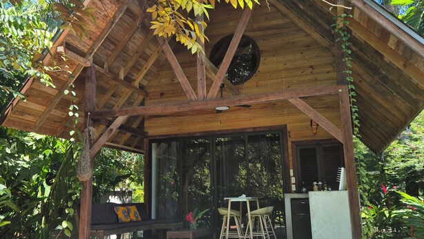 A wooden cabin with a pool, surrounded by lush greenery. - Cabañas Naturaleza (Bocas del Toro)