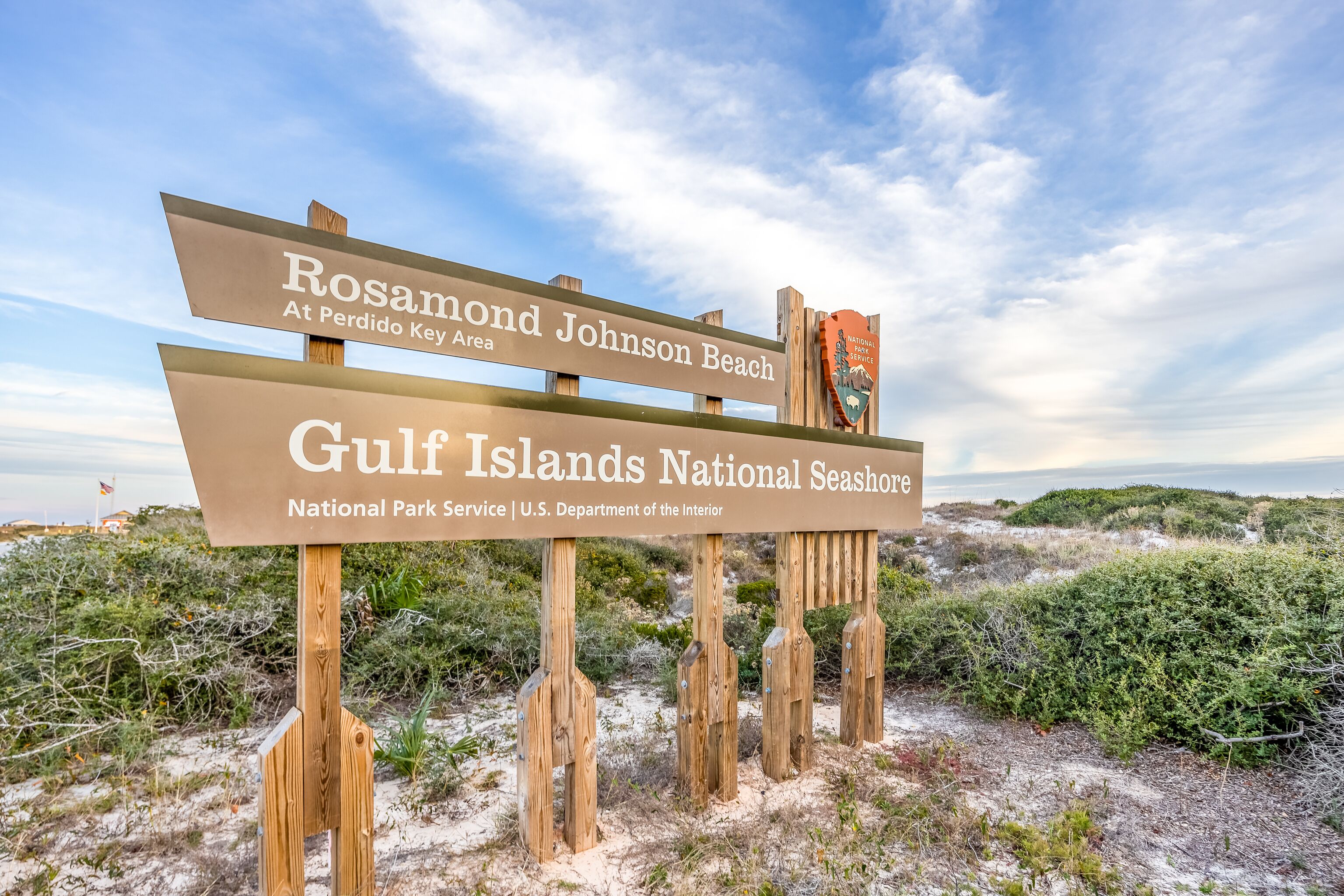 Un letrero de madera que indica 'Rosamond Johnson Beach' y 'Parque Nacional Islas del Golfo'.