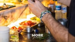 A person preparing a drink at a bar with various bottles and glasses. - More Ipanema (Rio de Janeiro)