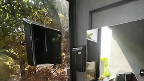 Um banheiro moderno com pia branca, espelho e janela com vista para o verde.