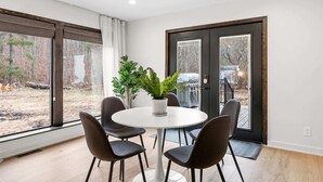 Un espace repas moderne avec une table ronde, quatre chaises et une plante en pot.