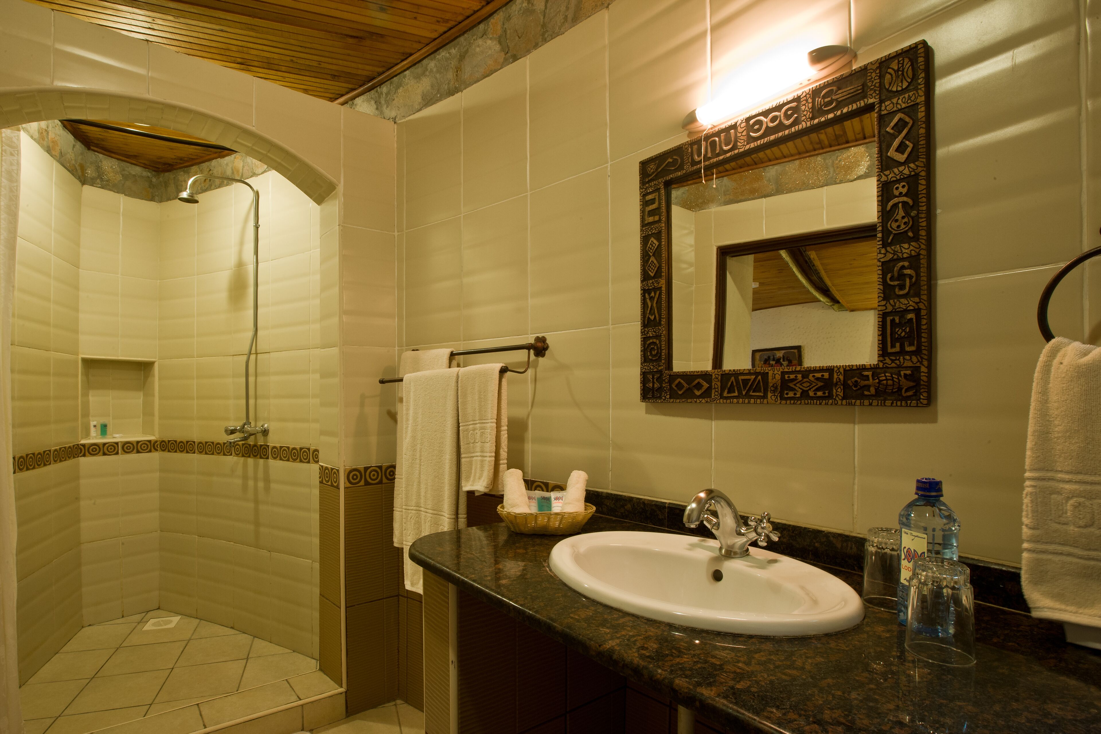 A bathroom with a shower, sink, and mirror.