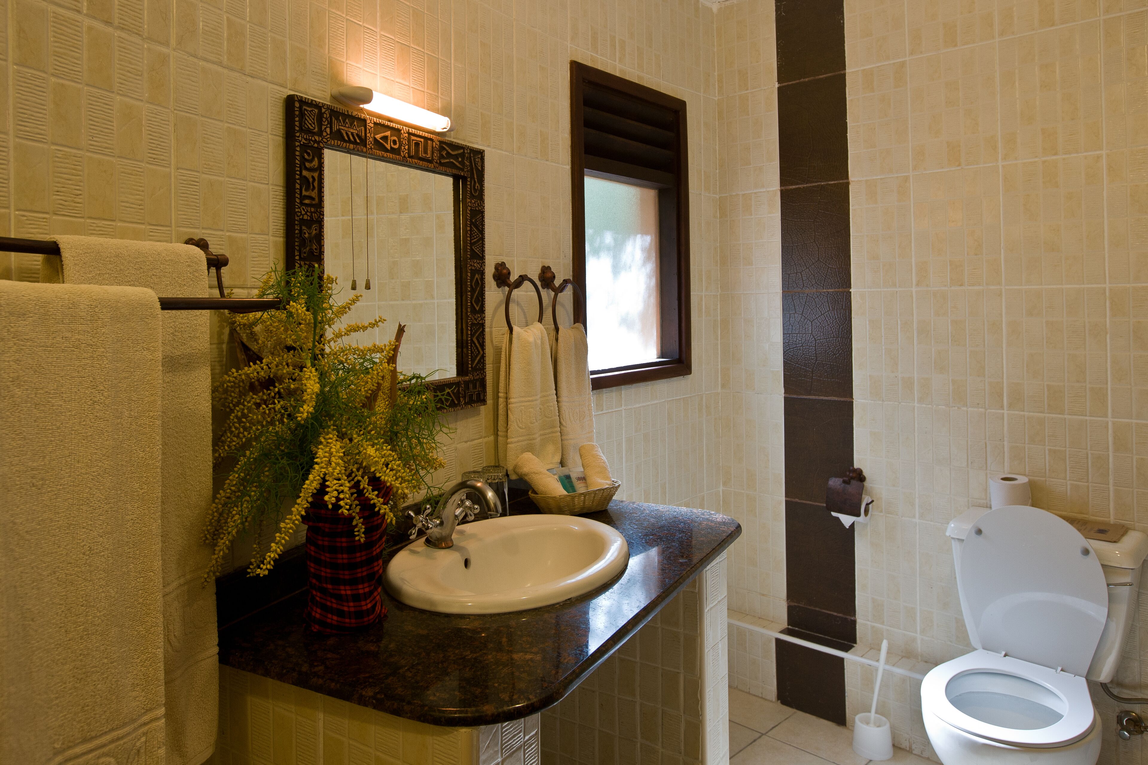 Une salle de bain équipée d’un lavabo, d’un miroir, d’un porte-serviettes et de toilettes.
