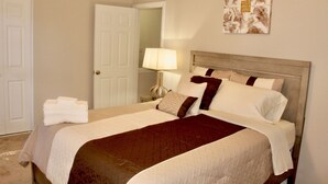 A neatly made bed with a brown throw blanket, a white pillow, and a beige headboard. - Cheerful 2 bedroom townhouse with indoor Fireplace (Tucker)
