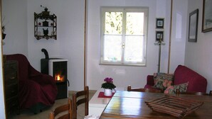 Een gezellige woonkamer met een open haard, een eettafel en comfortabele zitplaatsen.