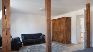 A room with a wooden wardrobe, a black sofa, and a grey rug. - Second home Heidelberg | Holiday apartment for short or long term (Heidelberg)