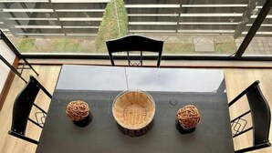 A rectangular dining table with a black surface, surrounded by four black chairs. In the center of the table, there is a woven basket. - Beautiful Suite in Cuenca (Cuenca)