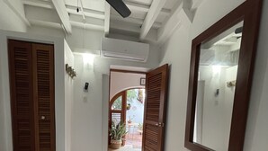 A bedroom with a bed, wooden doors, a ceiling fan, and a large mirror. - OLD MOON OLD SAN JUAN (San Juan)