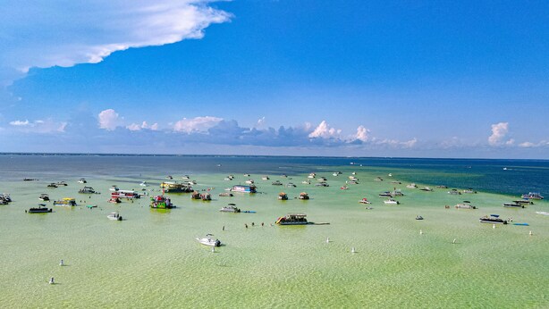 Een strand met veel boten en een heldere lucht.