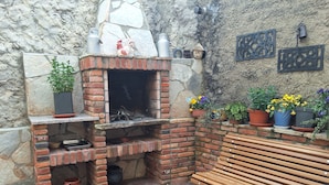 A brick-built outdoor kitchen with a built-in oven, a bench, and potted plants. - enjoy the nature (NOCEDO DE CURUEÑO)