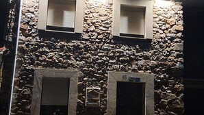 A stone building with two windows and a door, featuring a stone facade and a small balcony. - enjoy the nature (NOCEDO DE CURUEÑO)