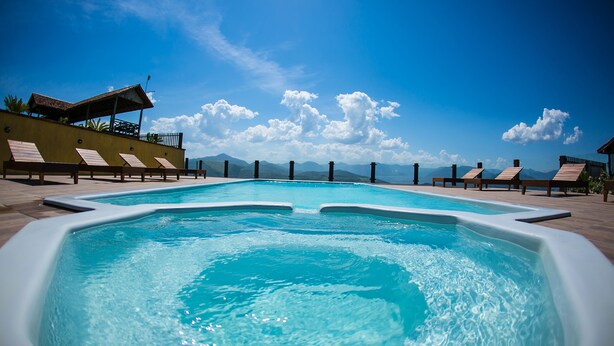 A swimming pool with lounge chairs and a view of mountains.