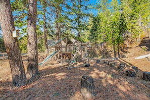 Children can play on the slide and climb in this forest play area.