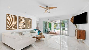Ein modernes Wohnzimmer mit einem weißen Sofa, einem Couchtisch und einem Deckenventilator.