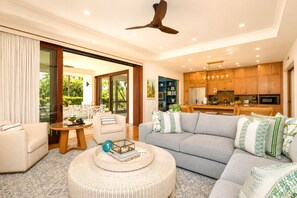 Uma sala de estar moderna com sofá, mesa de centro redonda e área de jantar com mesa e cadeiras.