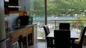 Eine Küche mit einem großen Fenster mit Blick auf eine Bucht und Segelboote.