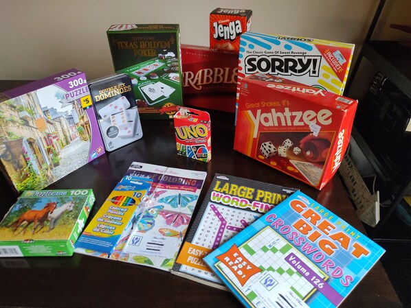 Une variété de jeux de société et de casse-têtes sont disposés sur une table.