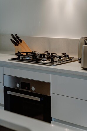 Kitchen features a gas stove with four burners and an oven.