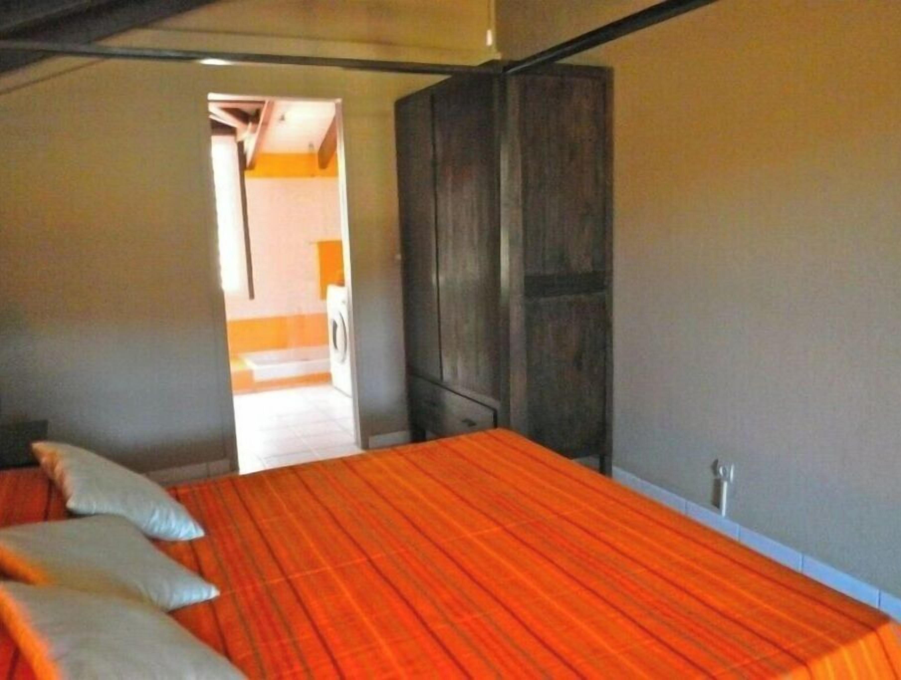 Une chambre à coucher avec un lit, des oreillers et une armoire.