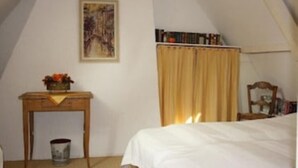 A bedroom with a bed, a desk, a chair, a bookshelf, and a painting on the wall. - Cozy farmhouse, Zeeland, original, large garden, wallbox 22KW (Gapinge)