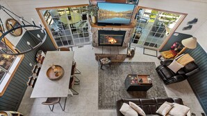 A spacious living area with a fireplace, a television, and a dining table with chairs.