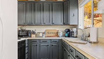 A kitchen with grey cabinets, a microwave, a toaster, and a coffee maker.